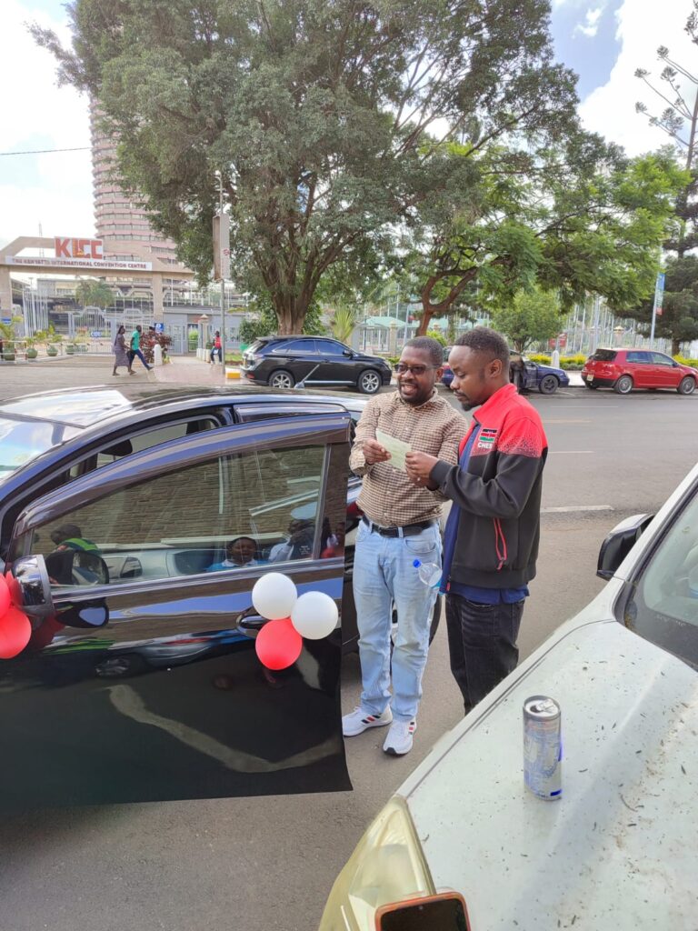 Mehtu receives the title to his new car! Photo from Kenya Chess Federation